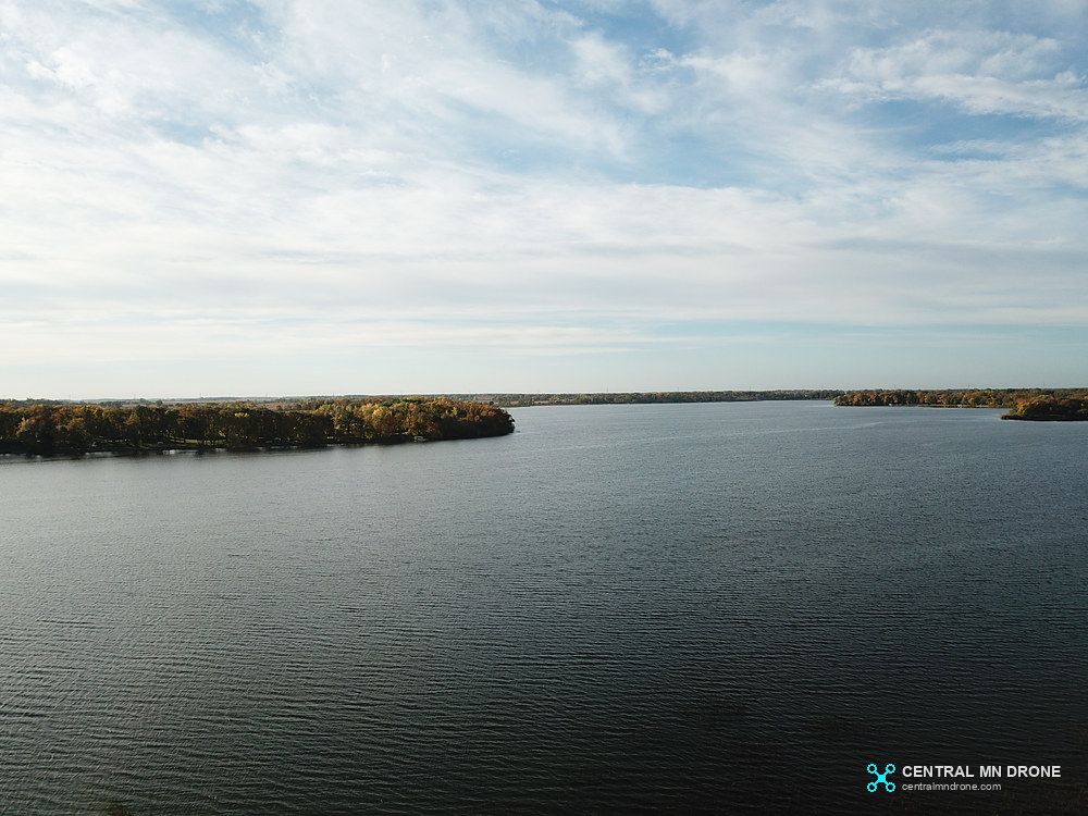 Aerial view over a calm Minnesota lake and wooded shoreline
