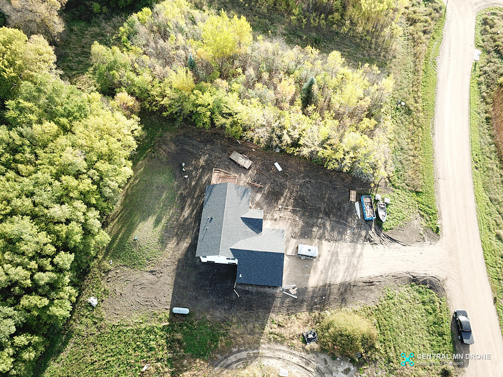 Top-down drone photo of a lake home lot surrounded by trees